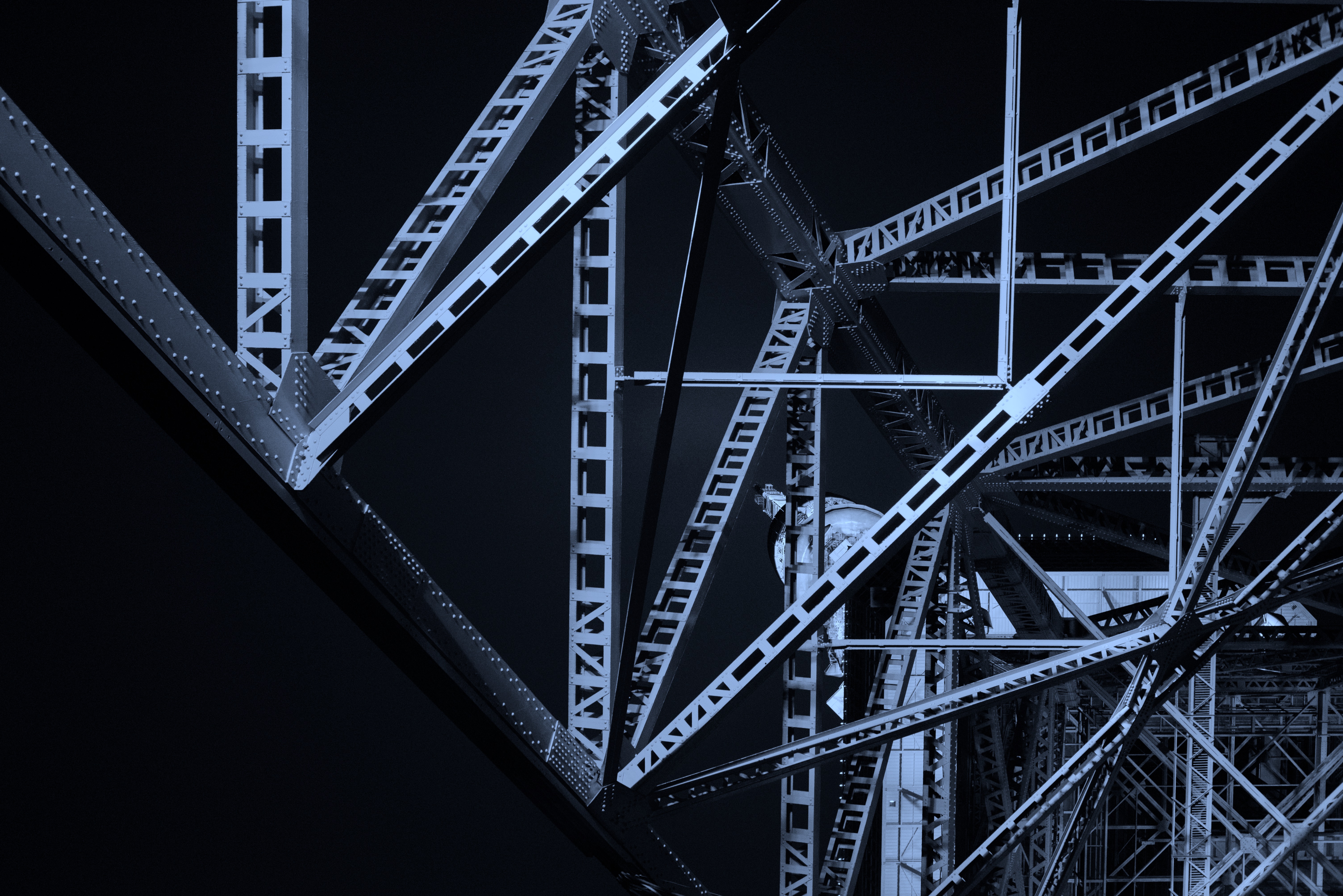 Steel beams jut at various angles across the frame and are cast in a blue light